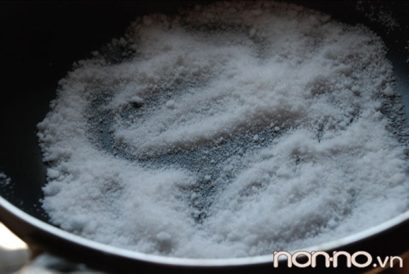 cho muối vào chảo rang với lửa nhỏ